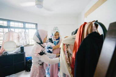 İki genç ve çekici Müslüman kadın girişimciler iş tartışma perakende ofis içinde yaşıyoruz. Onlar hem baş eşarp (hjiab) giyiyor ve kendi çalışmaları hakkında yoğun bir konuşmayı.