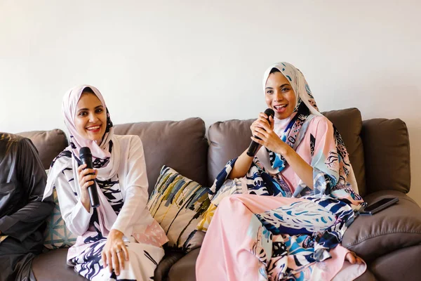 Duas Mulheres Muçulmanas Lenços Cabeça Estão Cantando Karaoke Seu Sistema — Fotografia de Stock