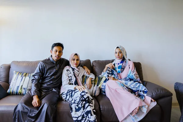 portrait of a Muslim Malay family at home with laptop during the Muslim festival of Hari Raya in Singapore, Asia.