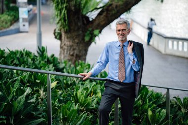 Şehir arka plan üzerinde takım elbise üst düzey işadamı portresi