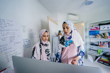 İki genç ve iş stratejisi toplantısı dynamicare işlerini görüşmek üzere. Onlar Müslüman Moda online ve mağaza içi perakende satmak. Ofiste bilgisayar üzerinde çalışan güzel Müslüman kadınlar