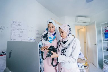 İki genç ve iş stratejisi toplantısı dynamicare işlerini görüşmek üzere. Onlar Müslüman Moda online ve mağaza içi perakende satmak. Ofiste bilgisayar üzerinde çalışan güzel Müslüman kadınlar