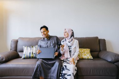 Müslüman Malay birkaç evde Müslüman Festivali sırasında laptop ile Singapur, Asya Hari Raya portresi.