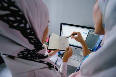 İki genç ve iş stratejisi toplantısı dynamicare işlerini görüşmek üzere. Onlar Müslüman Moda online ve mağaza içi perakende satmak. Ofiste bilgisayar üzerinde çalışan güzel Müslüman kadınlar