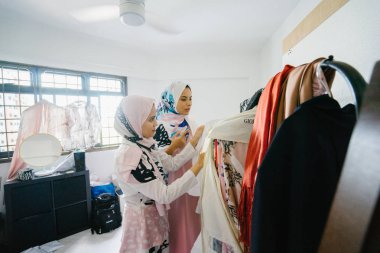 İki genç ve çekici Müslüman kadın girişimciler iş tartışma perakende ofis içinde yaşıyoruz. Onlar hem baş eşarp (hjiab) giyiyor ve kendi çalışmaları hakkında yoğun bir konuşmayı.