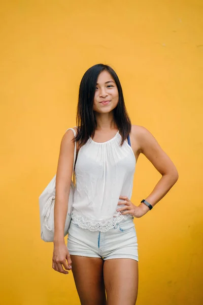 귀여운 아시아 여자와 스튜디오에 노란색 배경으로 카메라에 미소의 초상화 — 스톡 사진