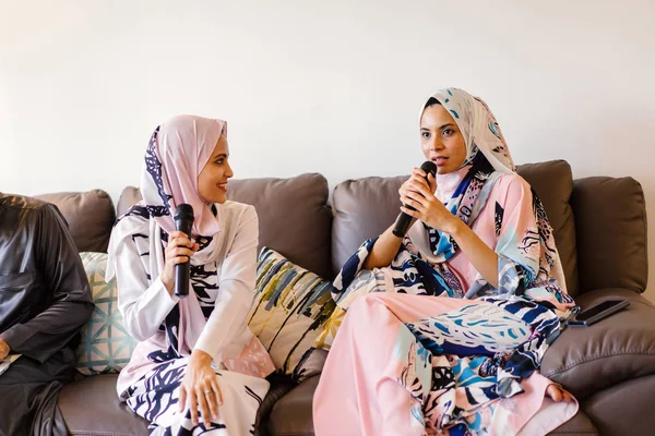 Duas Mulheres Muçulmanas Lenços Cabeça Estão Cantando Karaoke Seu Sistema — Fotografia de Stock