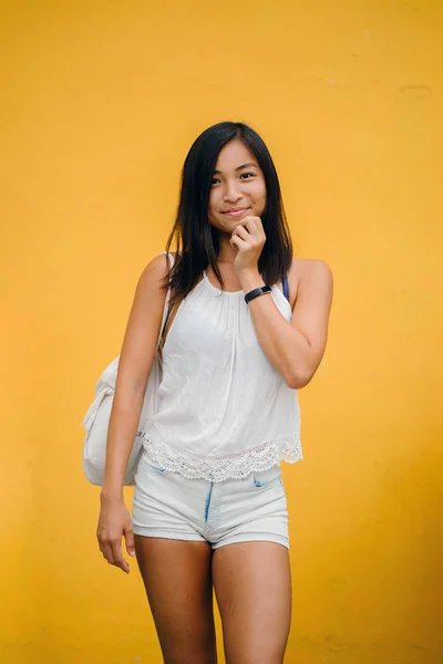 一个运动 可爱的中国亚洲女孩的肖像穿着舒适 微笑着对一个黄色背景在演播室的相机 — 图库照片