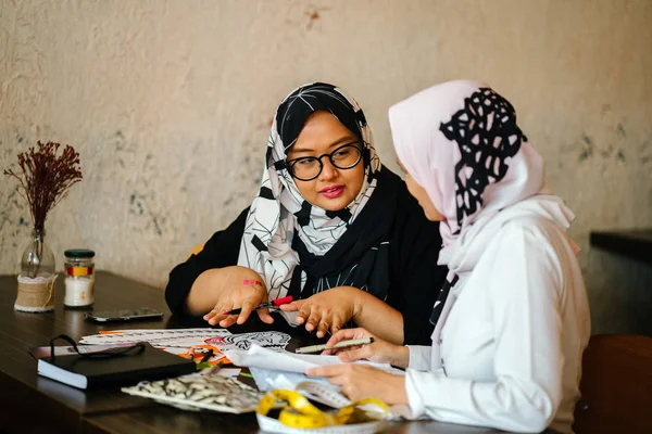两位有吸引力的穆斯林女企业家正在 Coworking 空间进行商业讨论 他们都穿着头围巾 Hjiab 并有一个激烈的谈话 他们的工作 — 图库照片