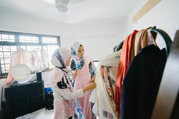 İki genç ve çekici Müslüman kadın girişimciler iş tartışma perakende ofis içinde yaşıyoruz. Onlar hem baş eşarp (hjiab) giyiyor ve kendi çalışmaları hakkında yoğun bir konuşmayı.