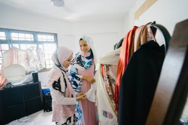 İki genç ve çekici Müslüman kadın girişimciler iş tartışma perakende ofis içinde yaşıyoruz. Onlar hem baş eşarp (hjiab) giyiyor ve kendi çalışmaları hakkında yoğun bir konuşmayı.
