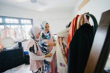 İki genç ve çekici Müslüman kadın girişimciler iş tartışma perakende ofis içinde yaşıyoruz. Onlar hem baş eşarp (hjiab) giyiyor ve kendi çalışmaları hakkında yoğun bir konuşmayı.