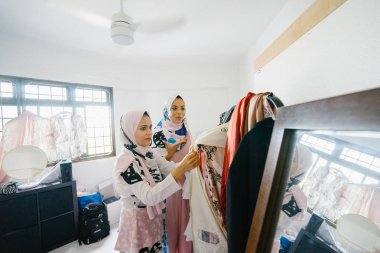İki genç ve çekici Müslüman kadın girişimciler iş tartışma perakende ofis içinde yaşıyoruz. Onlar hem baş eşarp (hjiab) giyiyor ve kendi çalışmaları hakkında yoğun bir konuşmayı.