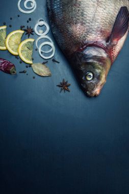 Lezzetli taze balık ve aromatik otlar, baharatlar ve sebzeler karanlık kayrak plaka üzerinde istiridye