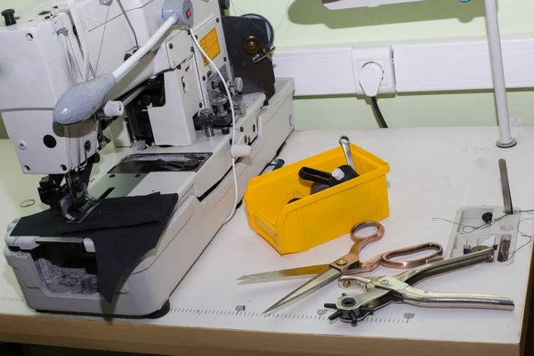 Máquina de costura overlock profissional com fio preto na oficina. Equipamento para afiação, bainha ou costura de roupas na loja de alfaiates . — Fotografia de Stock