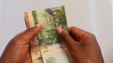 Kenya banknotlarını yavaşça sayan iki dişi Afrikalı el Nairobi, Kenya 'da çekilmiş bir video klip. Para, farklı değerler.