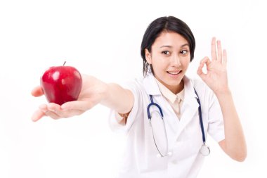 Kırmızı elma, ok el hareketi ile düşündüren kadın doktor gülümseyen