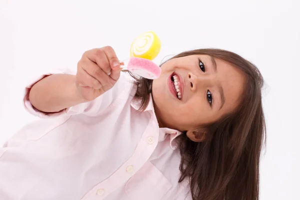 Aranyos kislány, játszik, eszik cukrot zselés édes candy — Stock Fotó