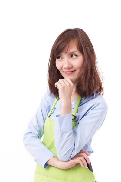 Mujer asiática con delantal mirando hacia arriba, pensando, planeando — Foto de Stock