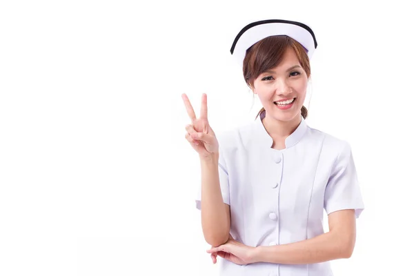 Ευτυχισμένος Ασίας νοσοκόμα που δείχνει προς τα επάνω 2 δάχτυλα, νίκη χέρι πινακίδα — Φωτογραφία Αρχείου