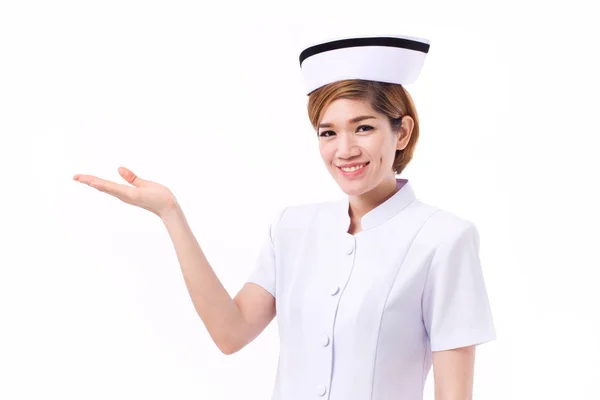 Enfermeira sorridente apresentando, mostrando sua mão ao espaço em branco — Fotografia de Stock
