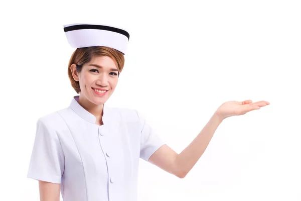 Smiling female nurse presenting, showing her hand to blank space — Stock Photo, Image