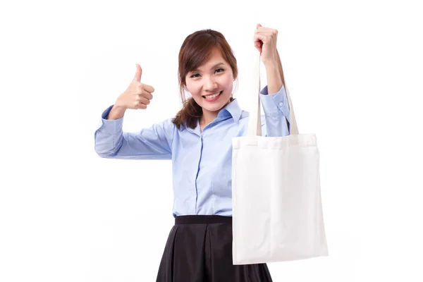 Happy woman carrying reusable cotton bag giving thumb up hand gesture Stock Image