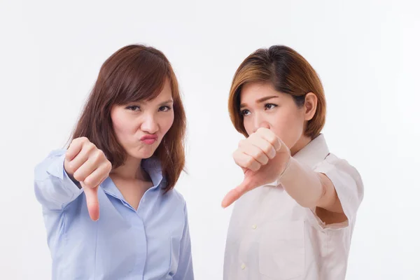 Frustrerade, arga kvinnor ger tummen ner pose — Stockfoto