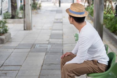 karayolu taşımacılığı için bekleyen otobüs durağında oturan adam