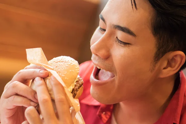 Чоловік їсть бургер, концепція нездорової нездорової їжі, фаст-фуд — стокове фото