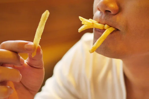 Mężczyzna jedzenie francuski frytek, ziemniaczane, chip, niezdrowe śmieci szybki — Zdjęcie stockowe