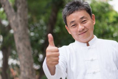 El hareketi yukarı gösteren Asyalı kung fu komuta sizde