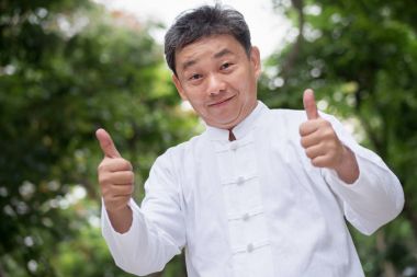 El hareketi yukarı gösteren Asyalı kung fu komuta sizde