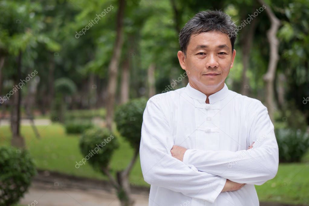 confident senior kungfu man master crossing arms