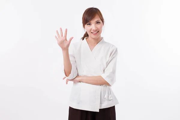 Žena wellness terapeut směřující nahoru 5 prsty, počítání, číslování — Stock fotografie