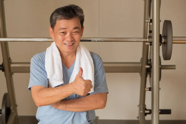 Saludable, feliz hombre mayor de entrenamiento en el gimnasio, dando pulgar hacia arriba ge — Foto de Stock