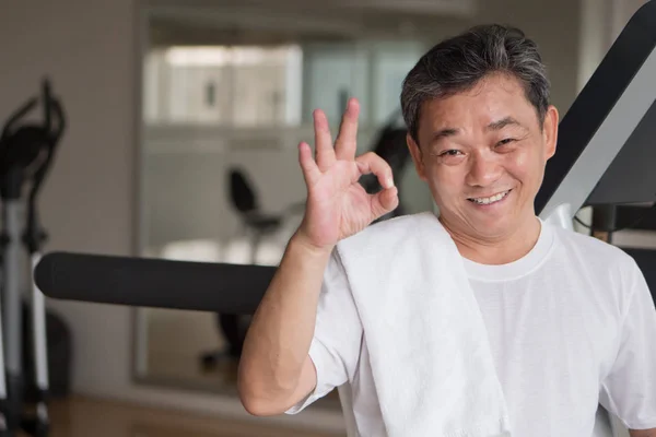 Saludable, hombre mayor feliz haciendo ejercicio en el gimnasio, dando ok dedo g — Foto de Stock