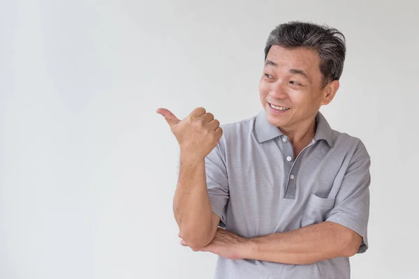 Viejo, de mediana edad, mayor asiático hombre apuntando thumb hasta dedo gesto — Foto de Stock