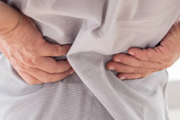 Hombre que sufre de dolor de espalda, retención de la mano — Foto de Stock