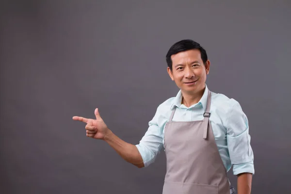 Confident man shopkeeper pointing up to space — Stock Photo, Image