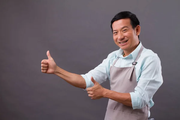 Exited man shopkeeper pointing thumb up to space — Stock Photo, Image
