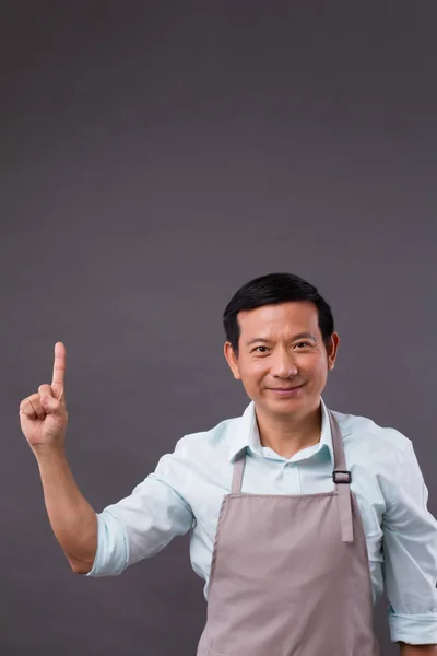 Confident man shopkeeper pointing up to space — Stock Photo, Image
