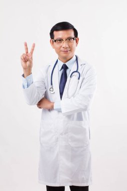 Kendine güvenen Asya erkek doktor 2 parmak, zafer el işaret 