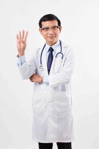 Jistý asijský lékař směřující nahoru 4 prsty — Stock fotografie