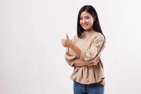 Casual woman pointing thumb up to blank space, studio isolated — Stock Photo, Image