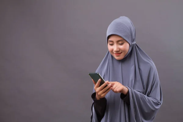 Spokojený úsměv muslimské ženy pomocí smartphonu — Stock fotografie