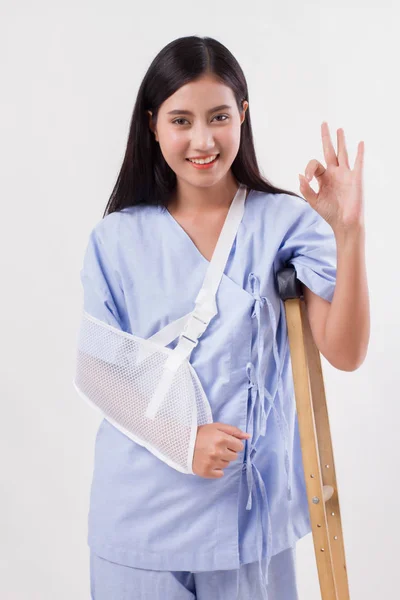 Mujer lesionada paciente apuntando hacia arriba gesto de la mano ok — Foto de Stock