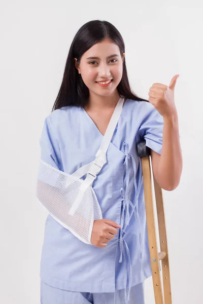 Mujer lesionada paciente apuntando con el pulgar hacia arriba gesto de distancia — Foto de Stock