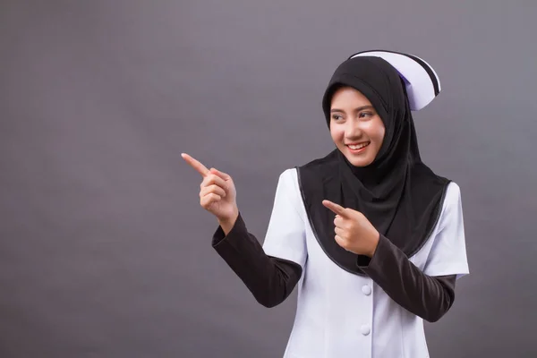 Muslimska sjuksköterska pekar uppåt finger — Stockfoto