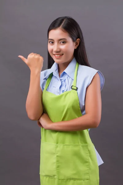 Woman worker pointing thumb up, presenting something on blank space — Stock Photo, Image